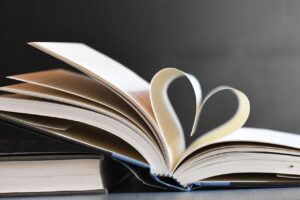 Her Kitabı Okumak Faydalı Mıdır? Open book with pages forming a heart, symbolizing love for reading and literature.