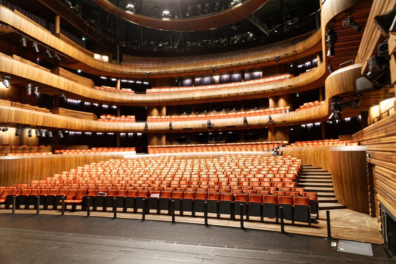 Services A spacious and modern indoor theatre featuring wooden interior and illuminated seating.